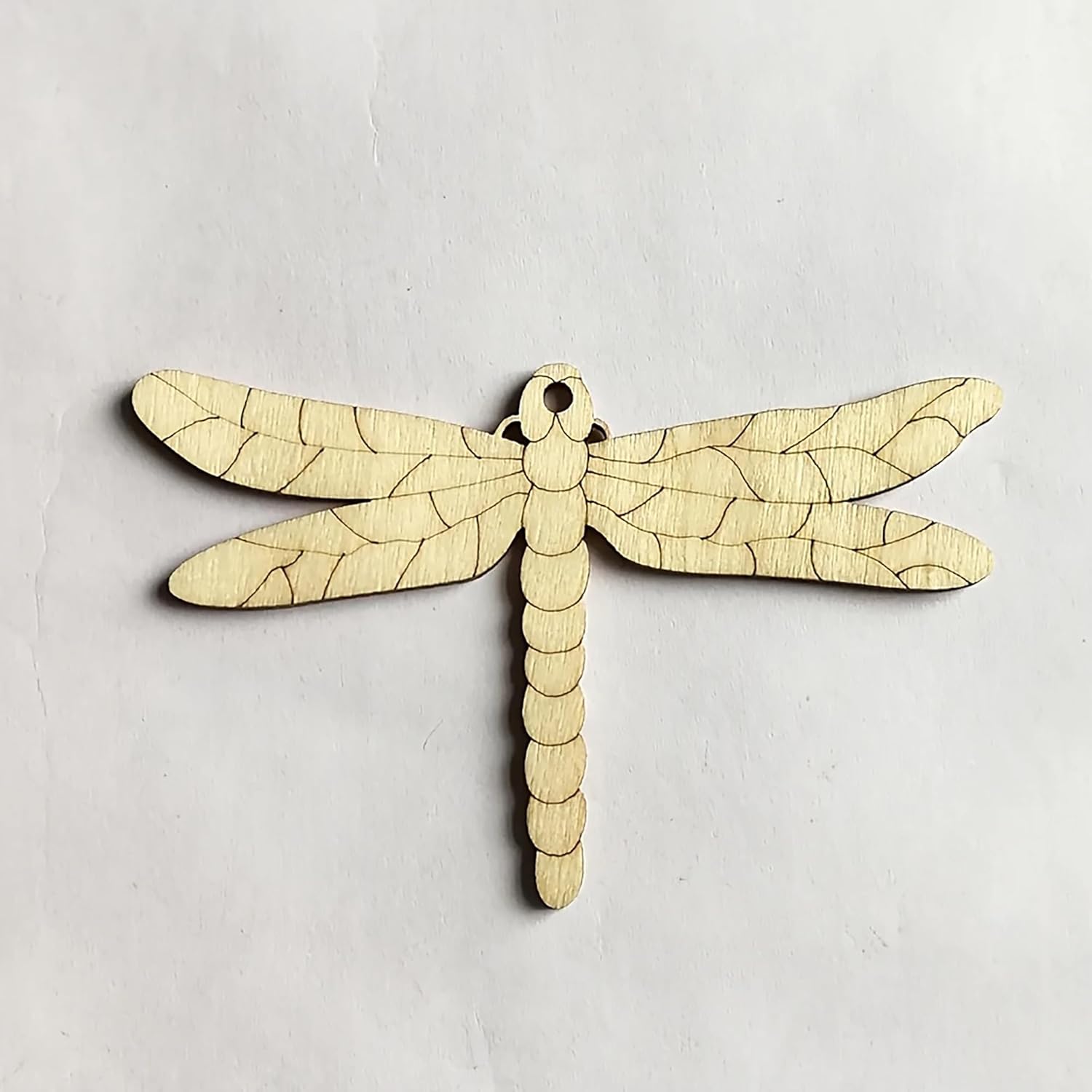 Wooden dragonfly ornament on a light gray background