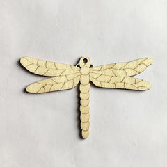 Wooden dragonfly ornament on a light gray background