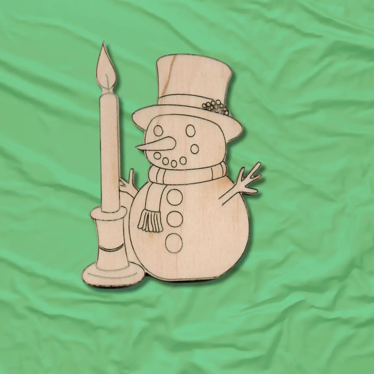 Wooden snowman decoration with a candle on a green fabric background