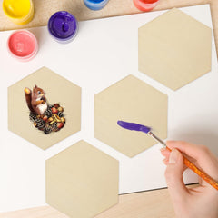 Hexagonal tiles with a painted squirrel design and a hand holding a paintbrush with purple paint.