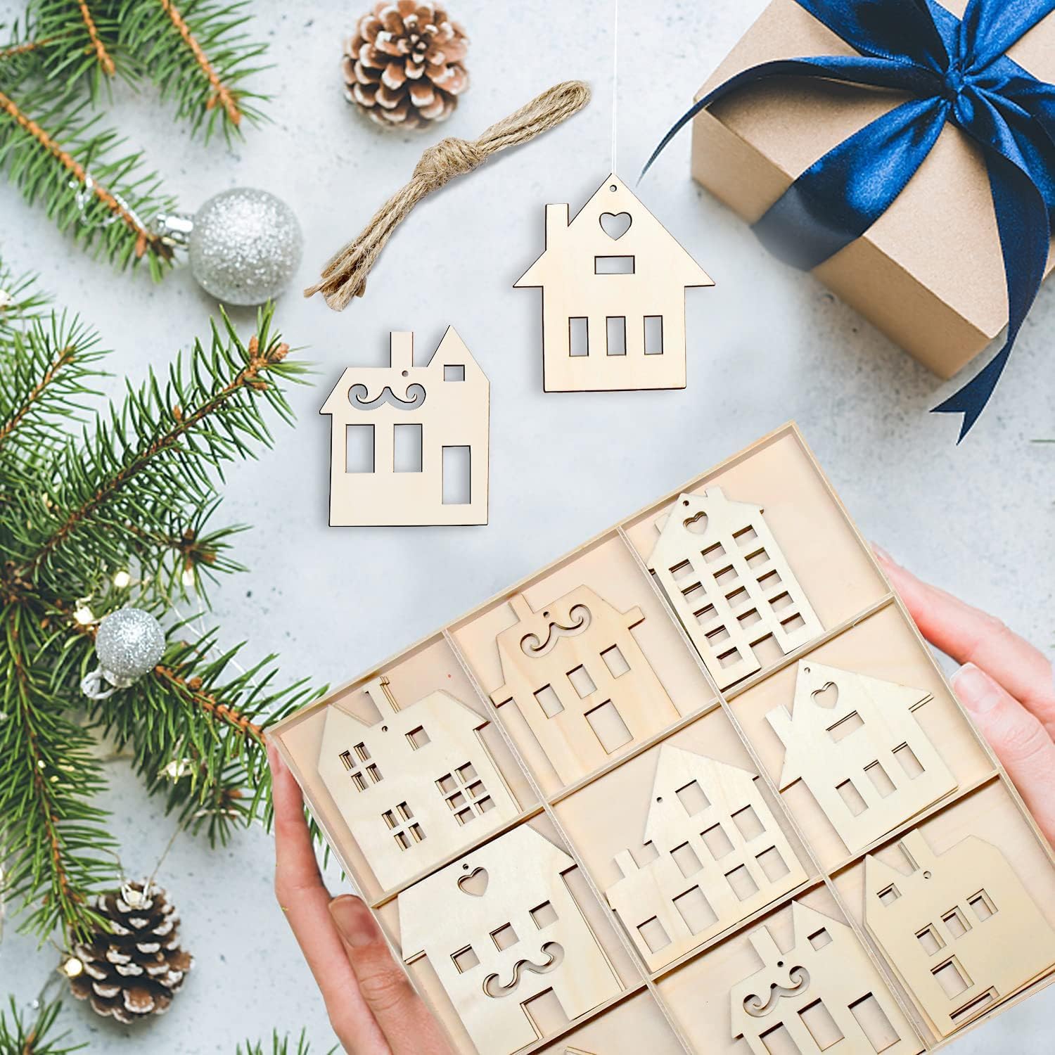 Wooden house-shaped ornaments on a box with Christmas decorations.
