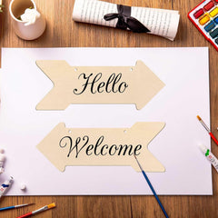 Wooden arrow-shaped signs with 'Hello' and 'Welcome' text on a table with art supplies.