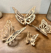 Four decorative wooden butterflies on a wooden surface with a neutral background