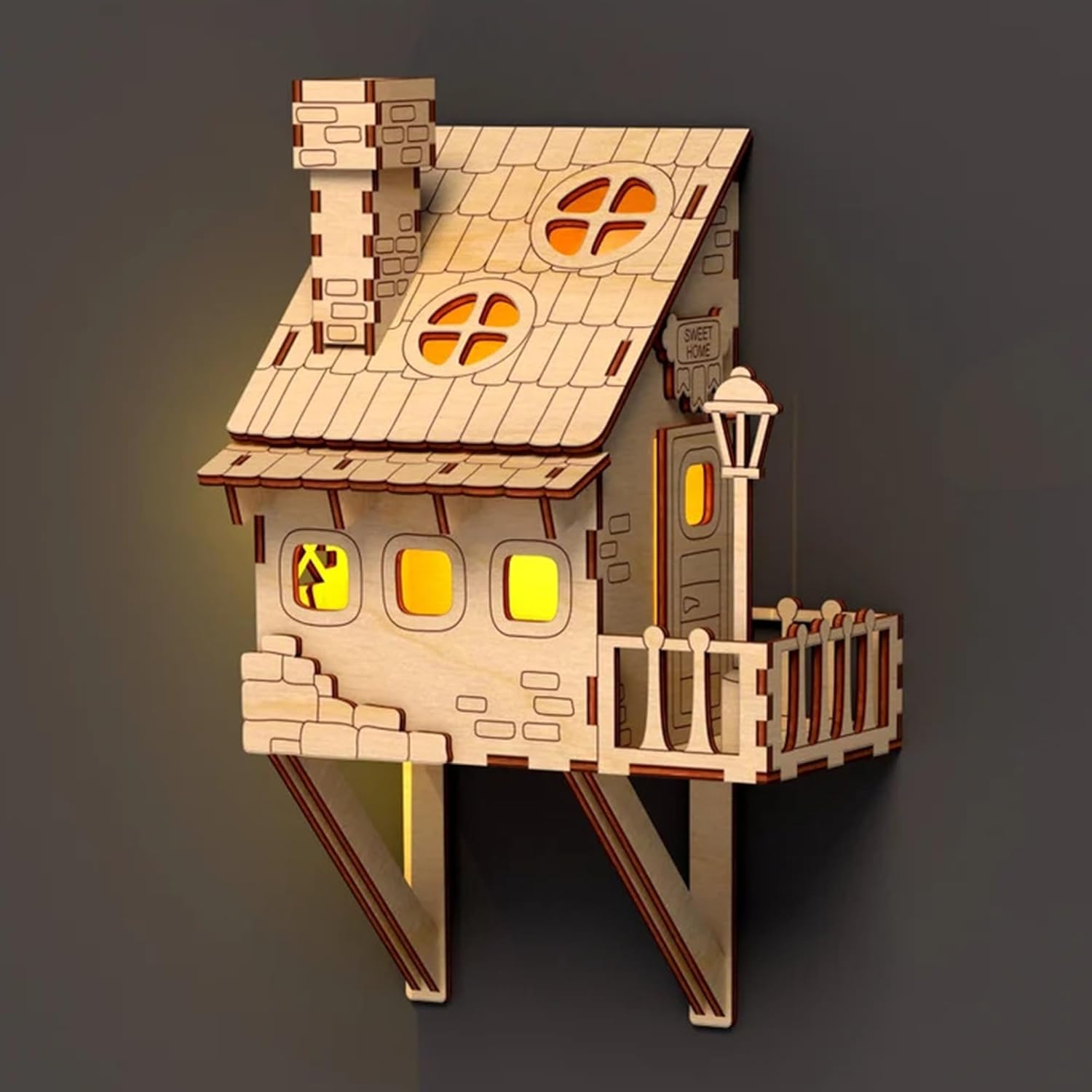 Wooden model of a house with glowing windows on a dark background