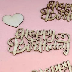 Wooden 'Happy Birthday' and heart decorations on a pink background