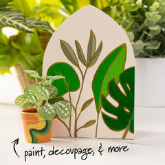 Decorative plant-themed card with green leaves and a small potted plant on a white surface.
