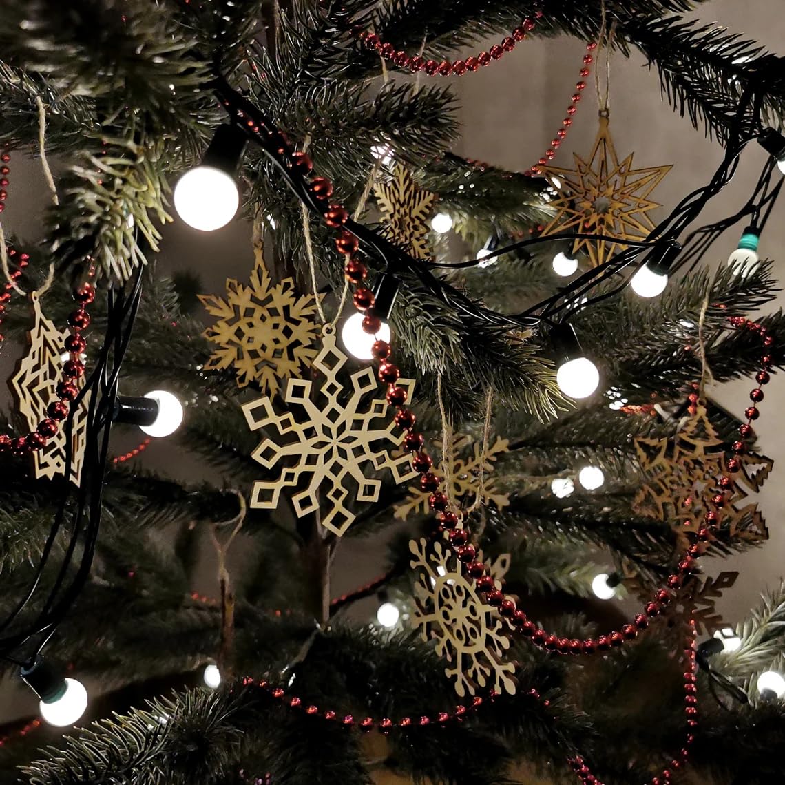 Decorative Christmas tree with gold snowflake ornaments and red beads.