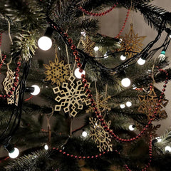 Decorative Christmas tree with gold snowflake ornaments and red beads.