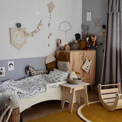 Children's bedroom with wooden furniture, toys, and decorative elements.