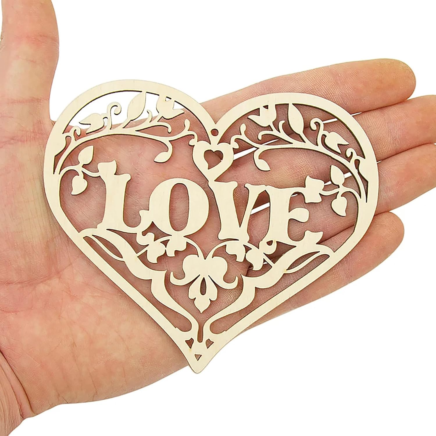 Decorative heart-shaped cutout with 'LOVE' in the center held in a hand against a white background
