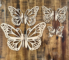 Four decorative butterfly shapes on a wooden surface