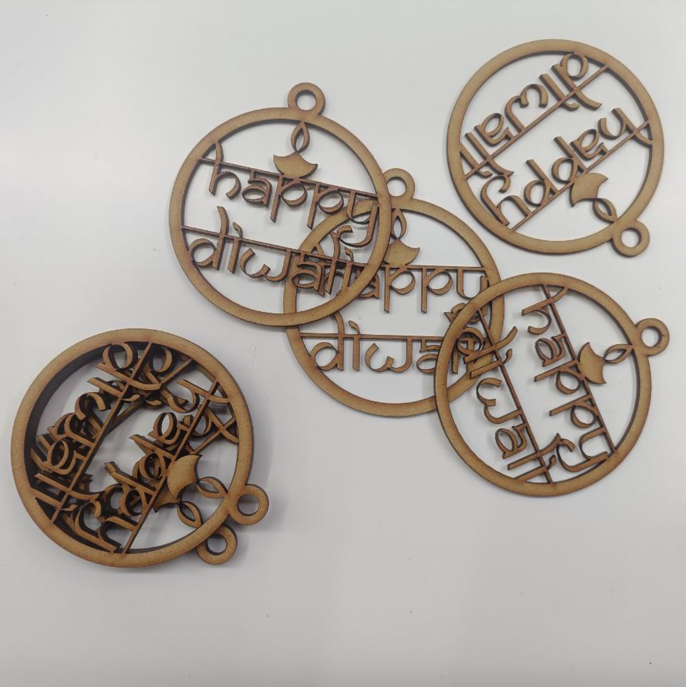 Decorative wooden pieces with 'Happy Diwali' text on a white background