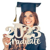Graduate holding a '2023 Graduate' sign with a white background