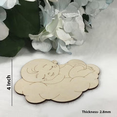 Wooden cutout of a baby on a cloud with measurements and thickness details, placed on a white surface with flowers in the background.