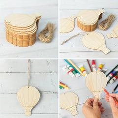 Wooden hot air balloon ornaments with string, markers, and a hand holding one.