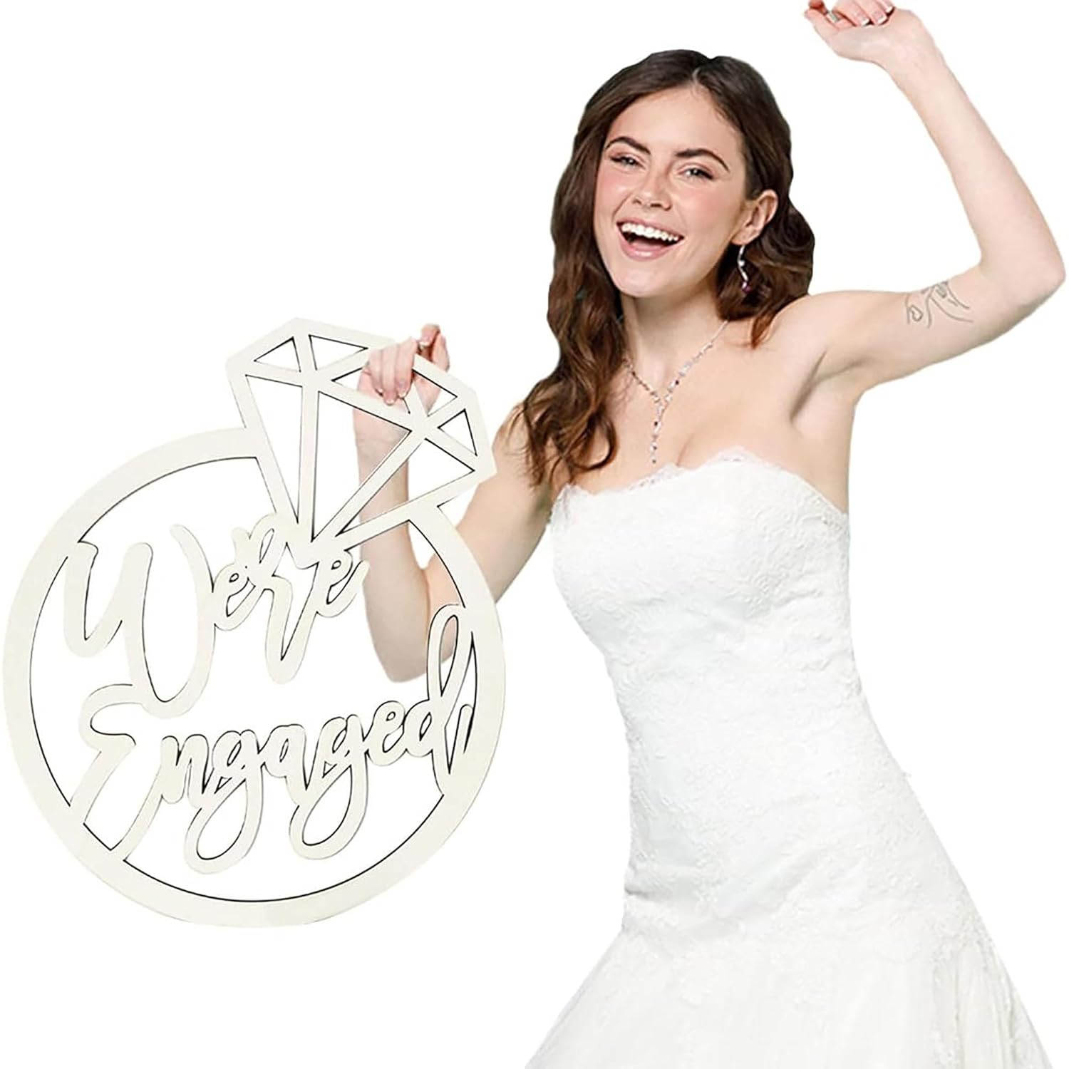 Woman in a white dress holding a 'We're Engaged' sign against a white background