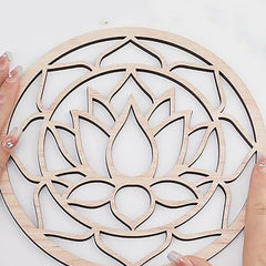 Wooden lotus flower wall art held by hands on a white background