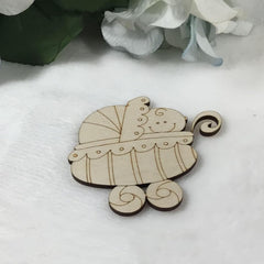 Wooden toy carriage on a white surface with flowers in the background