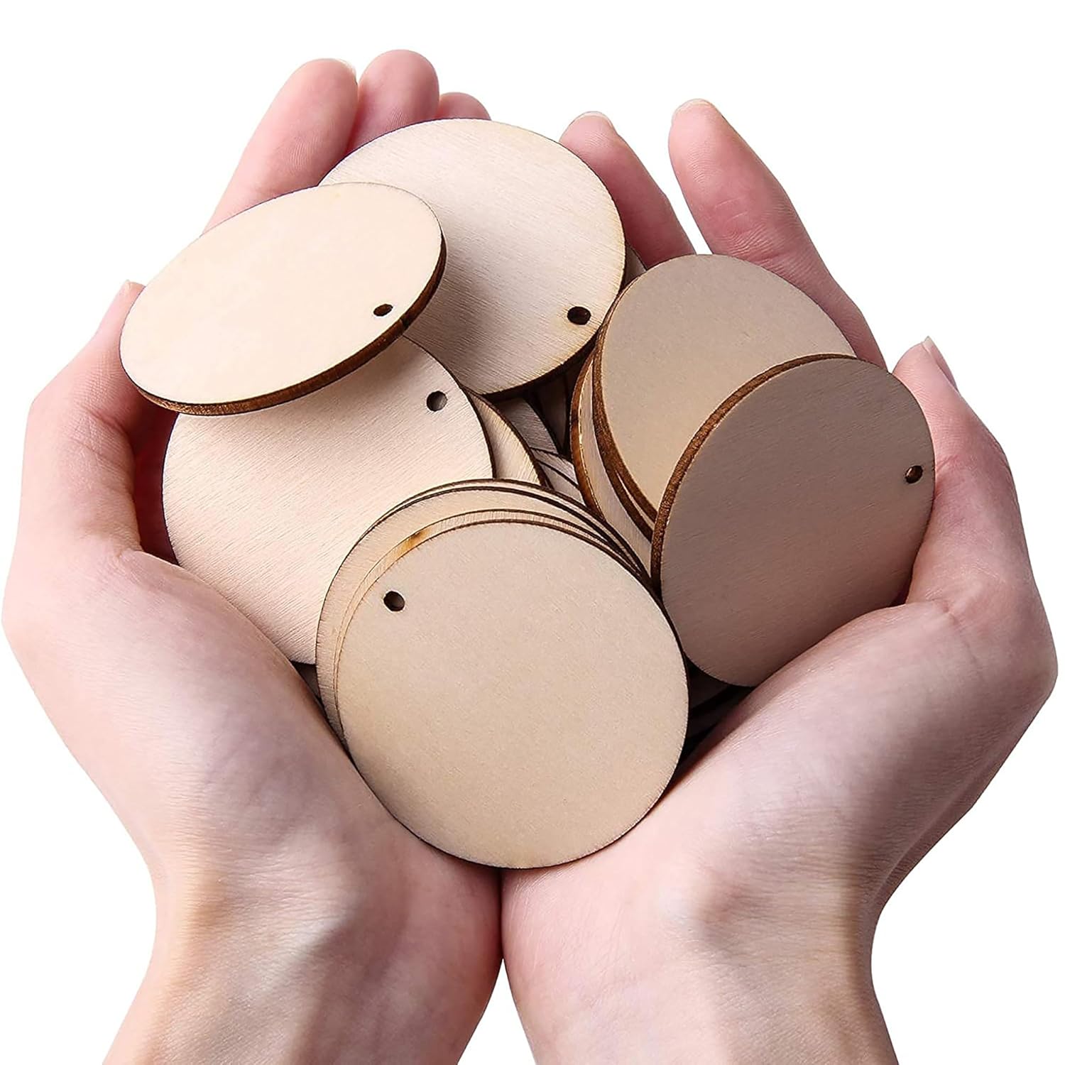 Hands holding a pile of round wooden cutouts on a white background