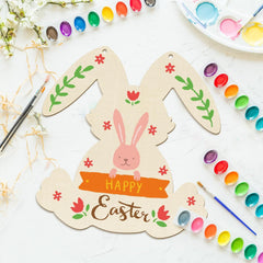Decorative Easter bunny card with paint supplies on a white surface