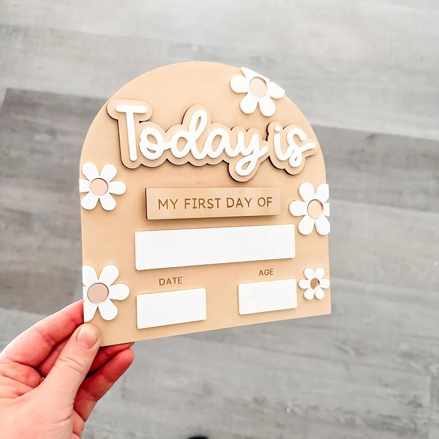 Wooden plaque with 'Today is my first day of' text and space for date and age on a gray background