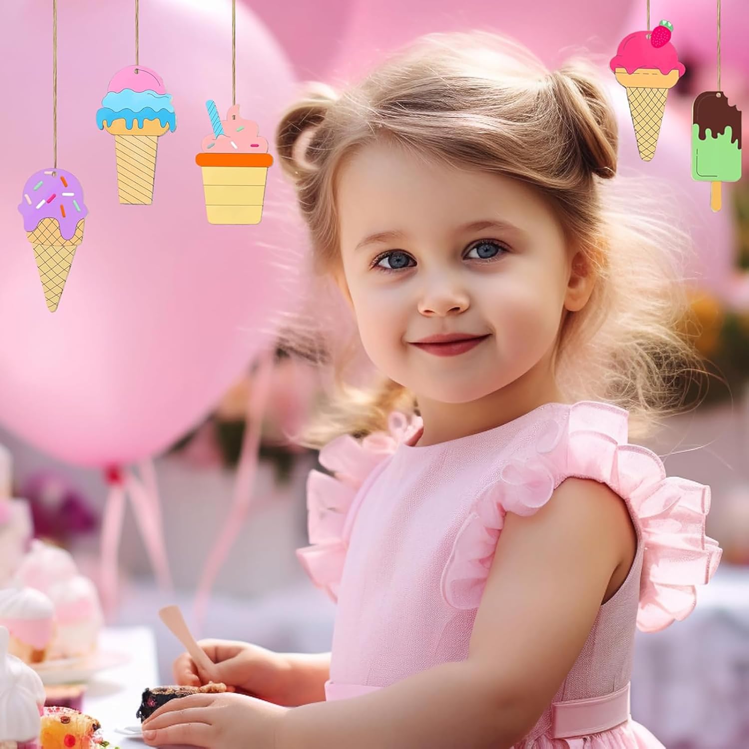 Young girl in a pink dress with ice cream-themed decorations in the background