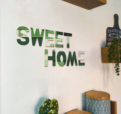 Decorative wall art with 'SWEET HOME' on a white wall.