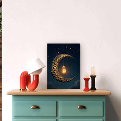 Decorative wall art with a crescent moon and lantern on a blue background, displayed above a teal cabinet.
