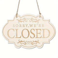 Decorative 'Sorry, We're Closed' sign with ornate designs on a white background