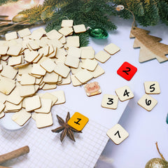Wooden square tiles with numbers and Christmas decorations on a white surface
