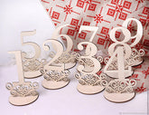 Decorative wooden table numbers on a white background with a red and white patterned fabric.