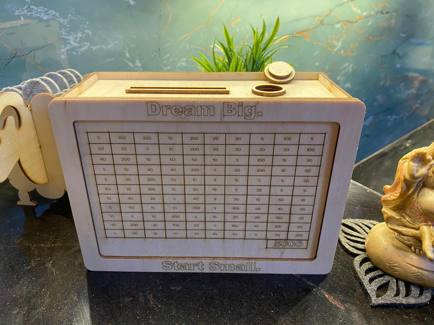 Motivational device with 'Dream Big' and 'Start Small' text on a marble surface.