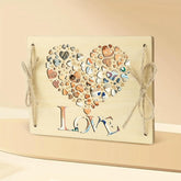 Decorative wall art with heart shape made of small stones and 'LOVE' text on a beige background