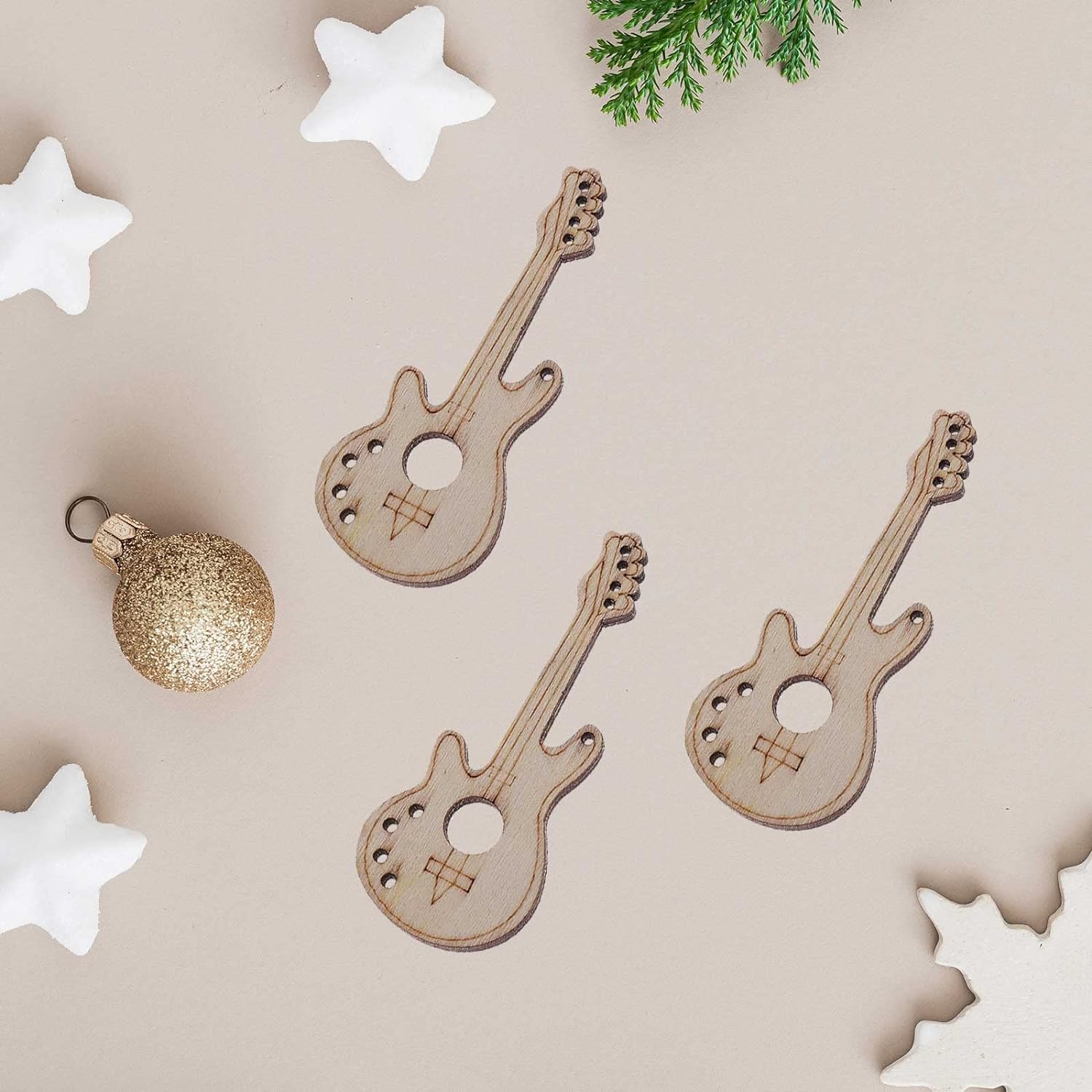Wooden guitar-shaped ornaments on a beige surface with decorative stars and a gold ornament.