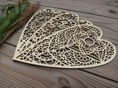 Decorative wooden heart-shaped cutout on a wooden surface with leaves and twigs.