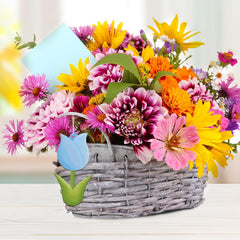 Colorful bouquet of flowers in a woven basket with a tulip-shaped sign.
