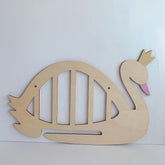 Wooden swan cutout with a pink beak on a white background