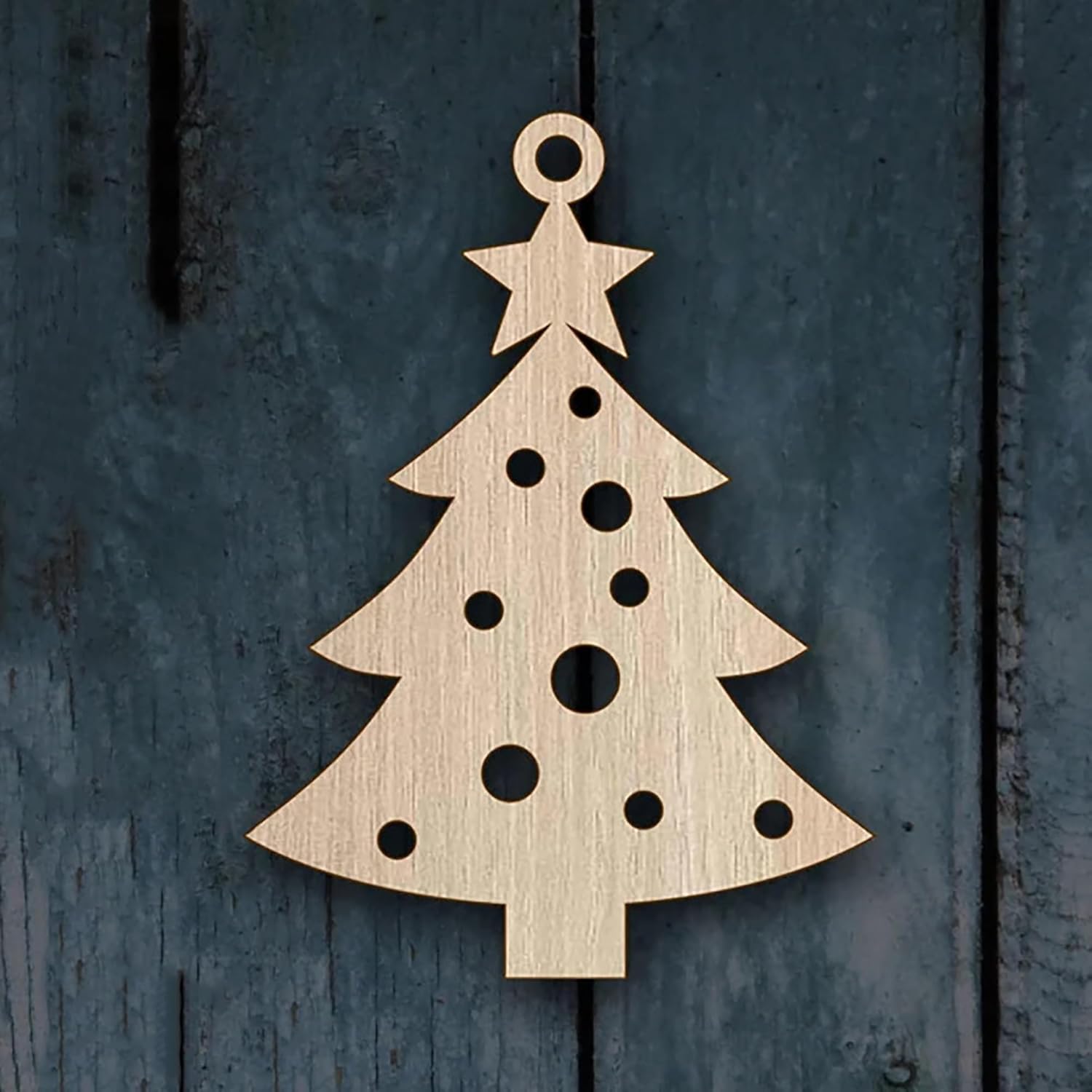 Wooden Christmas tree ornament on a textured dark blue background