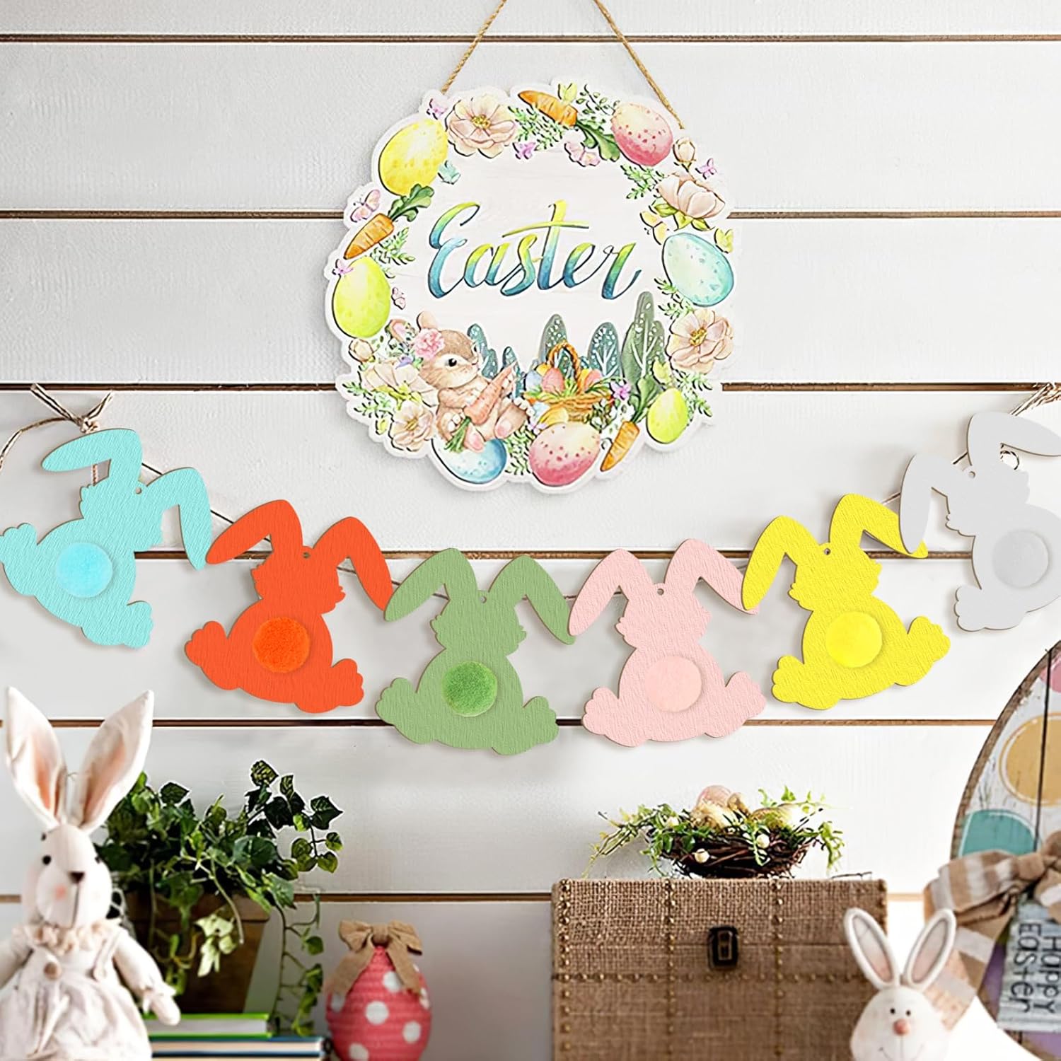 Decorative Easter wreath with colorful bunnies and eggs on a wooden wall.