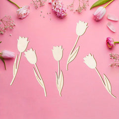 Wooden tulip decorations on a pink background with real tulips.