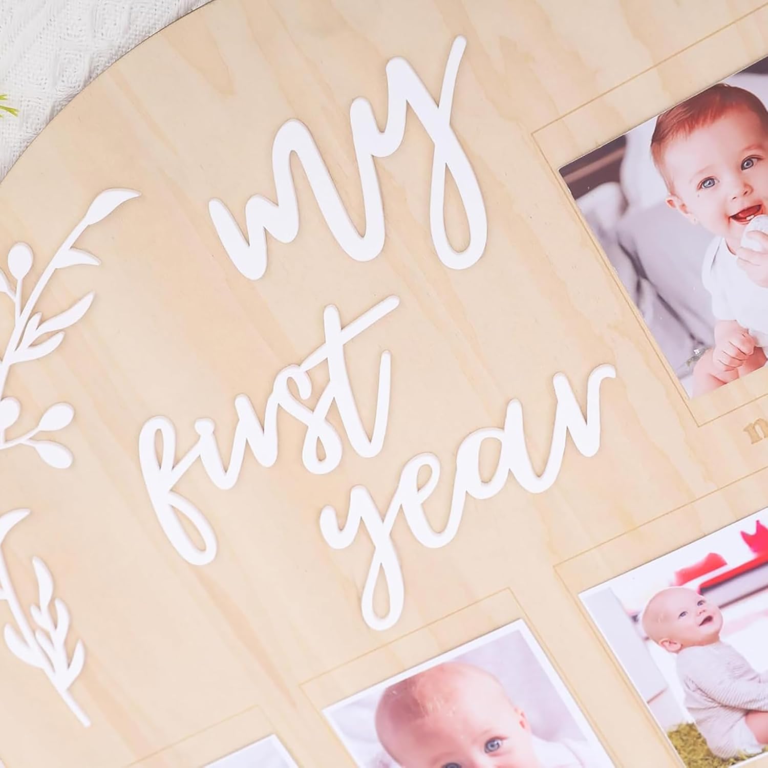 Baby photo album with 'My First Year' text and baby photos on a wooden surface.