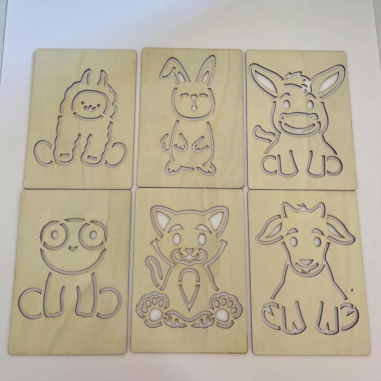 Six wooden cutouts of cartoon animals on a white background
