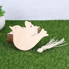 Wooden bird-shaped decoration with a tassel on grass