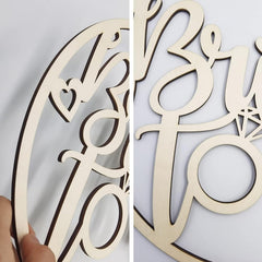 Wooden cutout of 'Mr. & Mrs.' with heart and ring design on a light gray background.