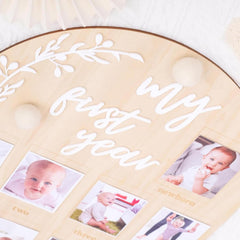 Memorial photo album titled 'My First Year' with baby photos on a light background