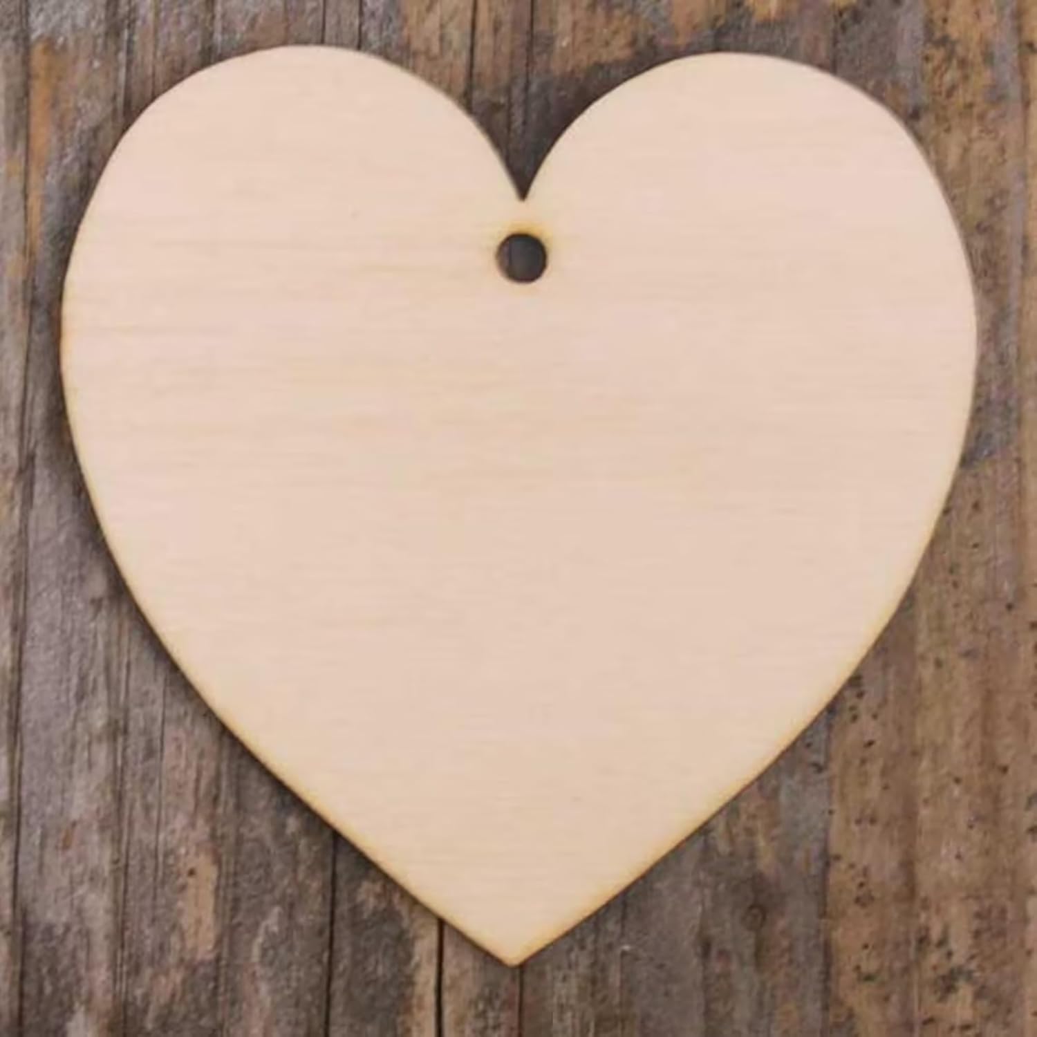 Heart-shaped beige ceramic piece on a wooden background