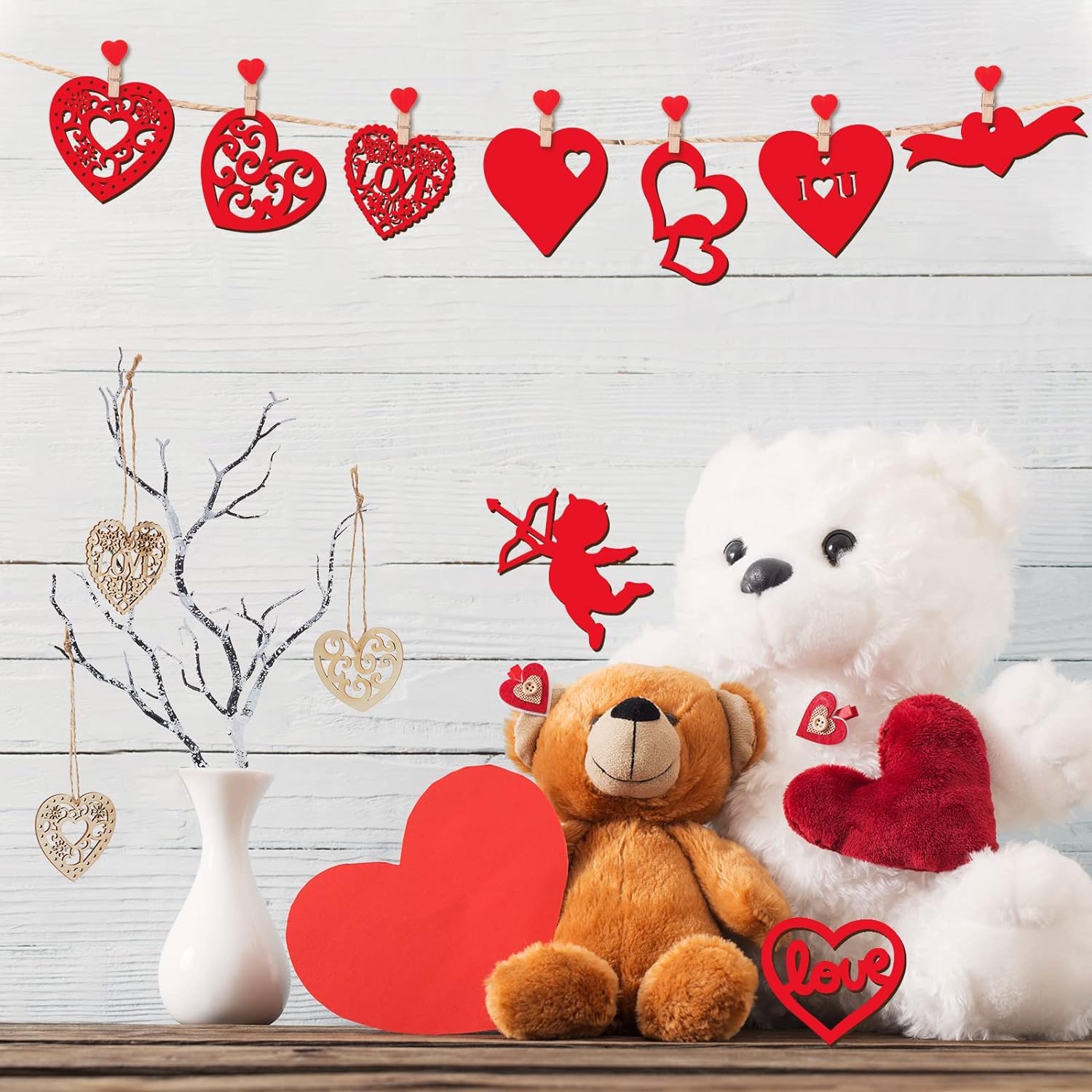 Valentine's Day decor with teddy bears, hearts, and a white vase on a wooden surface.