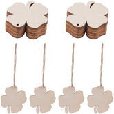 Wooden four-leaf clover tags with strings on a white background