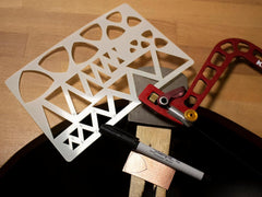 Stencil with geometric patterns on a wooden surface with tools.