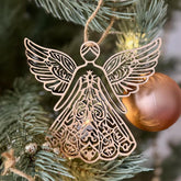 Decorative angel ornament on a Christmas tree with intricate designs.